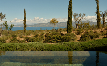 安缦卓熠度假村的豪华泳池馆，俯瞰宁静水景和远处山峦。