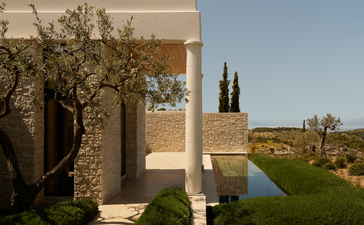 Deluxe pool pavilion at Amanzoe resort overlooking the Aegean landscape, with olive trees and stone architecture.