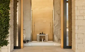 Pavilion bathroom at Amanzoe resort with minimalist design and warm stone finishes.