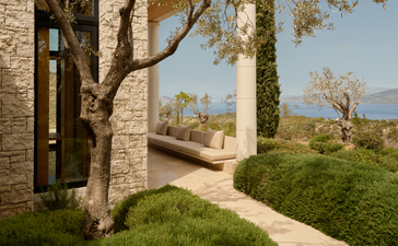 安缦卓熠度假村的泳池露台，石墙建筑、绿色植被与地中海风景相融。