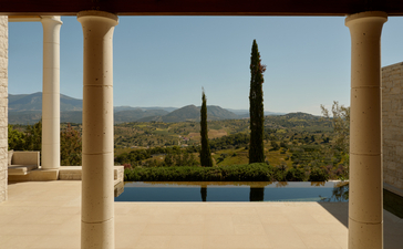 Pool pavilion with columns overlooking the Peloponnese landscape at Amanzoe.