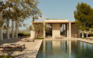Villa with swimming pool at Amanzoe, Greece, featuring stone architecture and sun loungers.