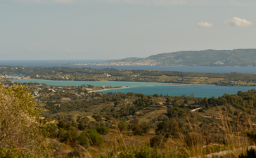 Elevated view of turquoise waters and surrounding landscape at Amanzoe, Greece.