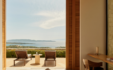 Villa interior at Amanzoe with open doors framing views across the Aegean landscape.