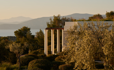 Villa terrace with loungers overlooking Aegean Sea at Amanzoe, Greece.