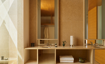 Amanzoe beach club cabana bathroom with wooden vanity, mirror and neutral tones.