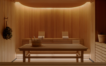 Espaço aquecido com painéis de madeira clara na parede e bancos de madeira na banya do Aman New York.