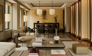 Suite Aman à l'Aman New York, avec salon spacieux, mobilier contemporain et baies vitrées.