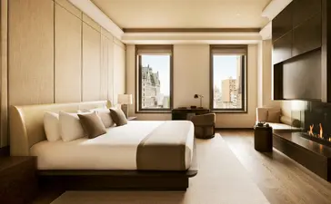 Chambre à trois lits à Aman New York, avec mobilier en bois clair et tons neutres.
