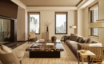 Salon spacieux d'une trois-chambres à Aman New York, avec sièges confortables et baies vitrées.
