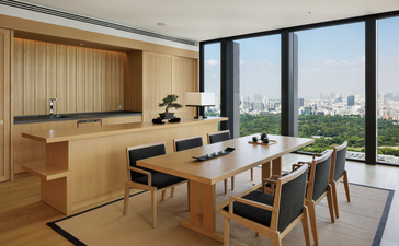 Aman Suite dining area with wooden kitchen, dining table and city views at Aman Tokyo.