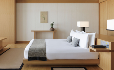 Chambre avec lit king-size dans une Grand Suite d'Aman Tokyo, au décor épuré et minimaliste.