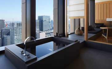 Grand Suite with floor-to-ceiling windows overlooking Tokyo skyline at Aman Tokyo hotel.