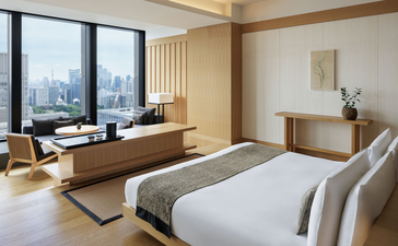 Panorama Suite principal bedroom at Aman Tokyo hotel, with floor-to-ceiling windows overlooking the city skyline.