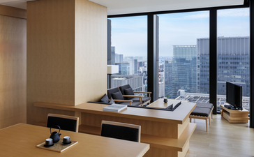 Salle à manger et lounge de la suite panoramique à Aman Tokyo, avec vue sur la ville.