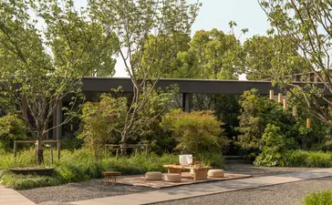 Courtyard at Amanyangyun with timber pavilion, seating area and verdant garden surrounded by trees.