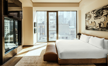 One-bedroom at Aman New York with floor-to-ceiling windows overlooking the city skyline.