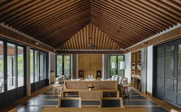 安缦诺怡度假村的三卧室海景泳池家庭住宅起居室，配木质天花板和落地窗。