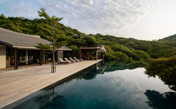 Three-bedroom ocean pool family residence terrace at Amanoi, Vietnam, with wooden deck overlooking infinity pool and forested hillside.