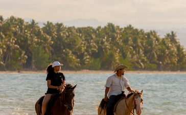 Deux cavaliers à cheval sur la plage d'Amanera, resort en République dominicaine.