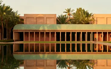 Bassin reflecting the terracotta architecture of Amanjena resort, Morocco.