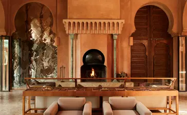 Lounge à Amanjena, resort au Maroc, avec arches marocaines et sièges en cuir chamois.