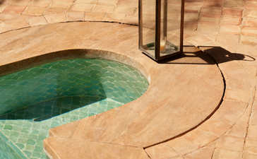 安缦珍纳度假村的游泳池细节，展示沙色露台与绿松石色池水。