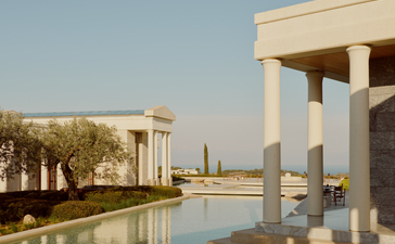 Amanzoe's waterfront canal reflecting classical columns under clear Greek skies in Porto Heli.