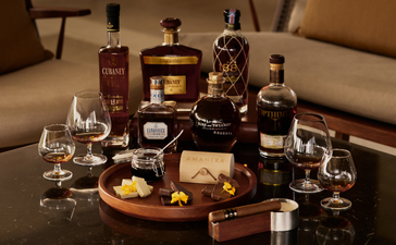 Rum and chocolate tasting selection at Amanera resort, featuring bottles, glasses and tasting portions arranged on a dark surface.