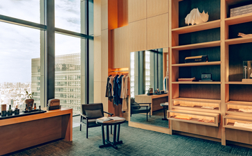 Aman Tokyo retail boutique with wooden shelving, curated essentials display, and city views.