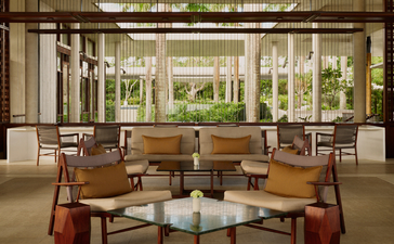 Bar lounge at Amanera resort in the Dominican Republic, with wooden furnishings and garden views.