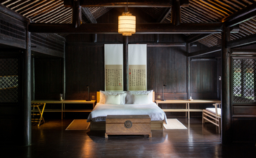 Contemporary spa treatment room at Amanfayun with stone massage table and warm lighting.