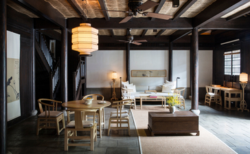 Amanfayun suite with dark wooden beams, lantern lighting, and traditional furnishings opening to garden views.