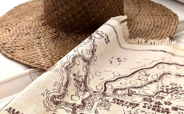 安缦湾澜度假村冒险地图，配以草帽和指南针。