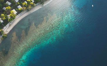 安缦湾澜度假村的海滨鸟瞰图,展示金色沙滩与碧蓝海水相接的景观。