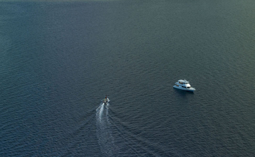 安缦湾澜度假村外的萨莱湾海域，一艘小船在平静的蓝色海水中航行。