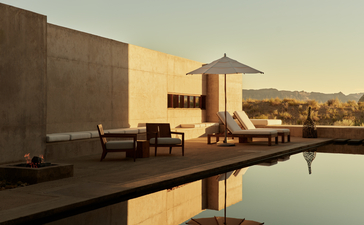 Amangiri suite with reflecting pool at sunset, Utah desert landscape in background.