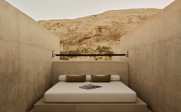 Minimalist principal bedroom at Amangiri with concrete walls and framed desert landscape above bed.