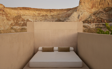 Chambre Girijaala avec lit blanc et vues sur les roches ocre d'Amangiri, en Utah.