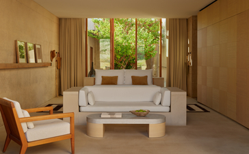 Girijaala Suite bedroom at Amangiri resort, with neutral furnishings and garden views through large windows.