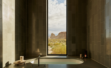 Mesa pool suite bathtub at Amangiri with desert landscape view through floor-to-ceiling windows.