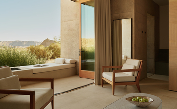 Desert suite at Amangiri with warm earth tones, floor-to-ceiling windows, and views of the arid landscape.