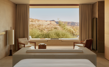 Desert suite bedroom at Amangiri with bed facing expansive window overlooking arid landscape.