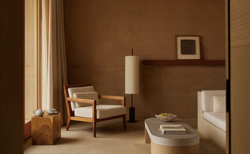 Suite Mesa avec fauteuil en bois, luminaire cylindrique et vue sur le désert à Amangiri resort.