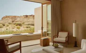 Orchard Suite at Amangiri with floor-to-ceiling window overlooking desert landscape and minimalist furnishings.