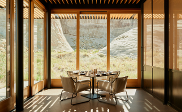Camp Sarika restaurant at Amangiri resort, with floor-to-ceiling windows overlooking desert landscape.