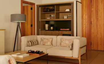 Camp Sarika accommodation pavilion with cream sofa and wooden shelving at Amangiri, Utah.
