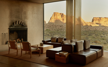 Main pavilion at Amangiri with floor-to-ceiling windows framing desert rock formations at sunset.