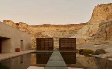 Wellness pool at Amangiri with wooden pavilion and desert cliffs reflected in still water.