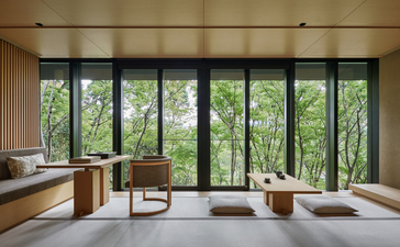 Principal bedroom at Aman Kyoto with expansive glazing overlooking verdant gardens and natural light.